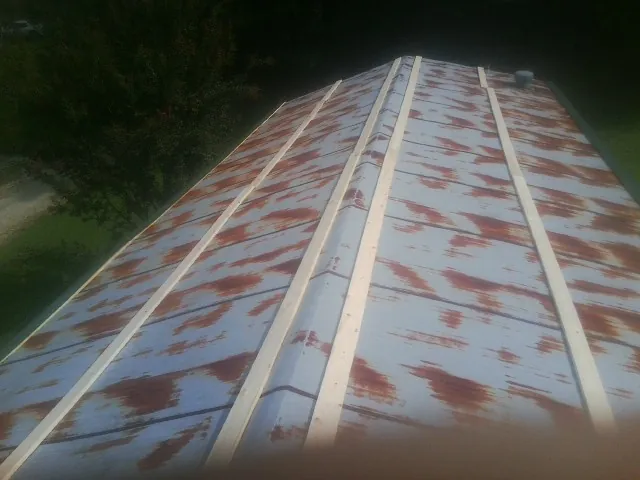 Rusted metal roof panels with new wood purlins before replacement — Storm Damage Roof Repair in Foley by Roofing Brothers